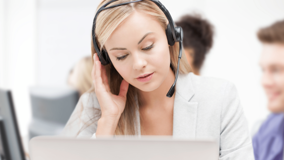 Woman on the phone, looking frustrated as she manually takes orders